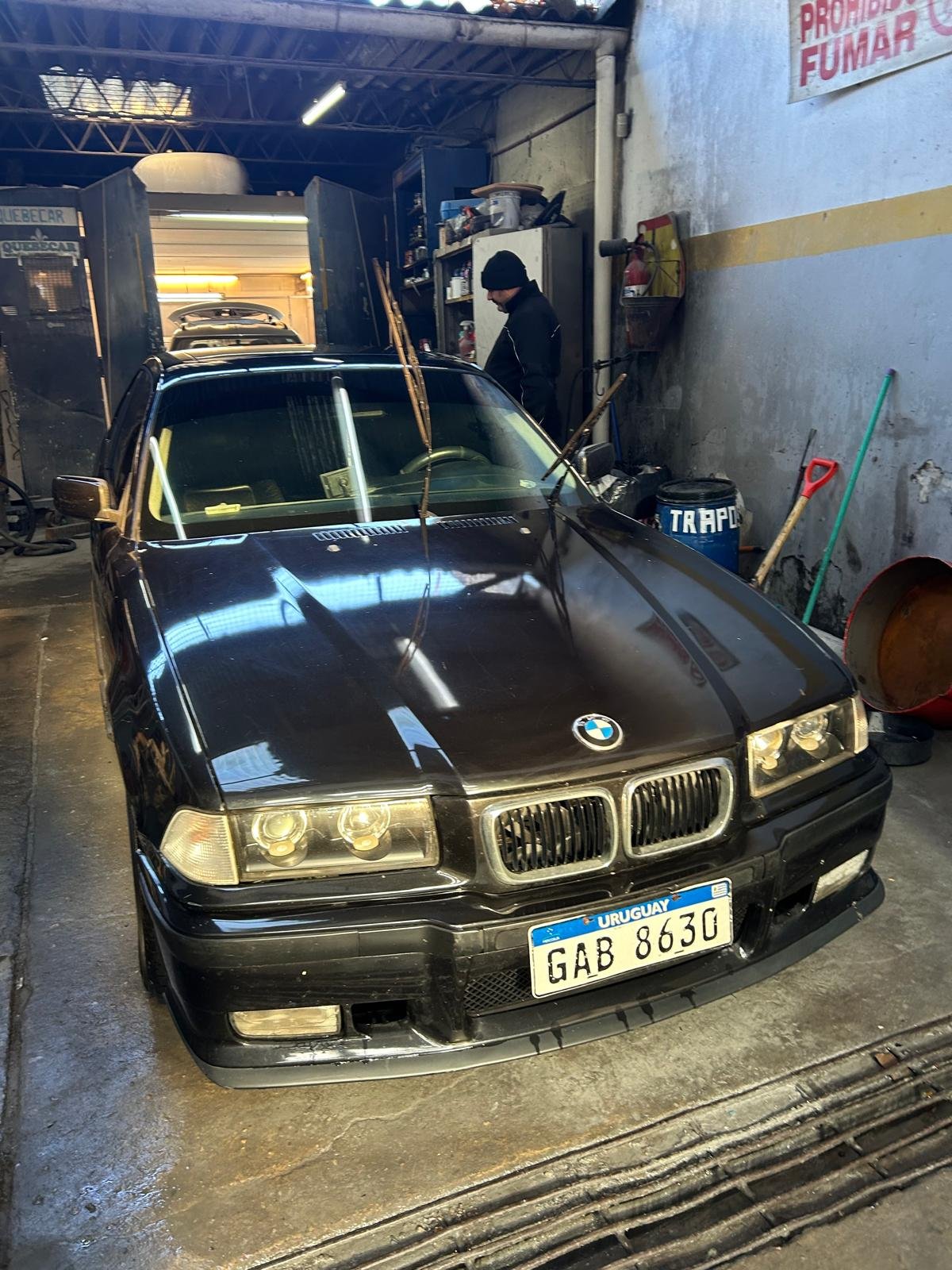 BMW 328i negro de frente, terminado, dentro del taller Quebecar