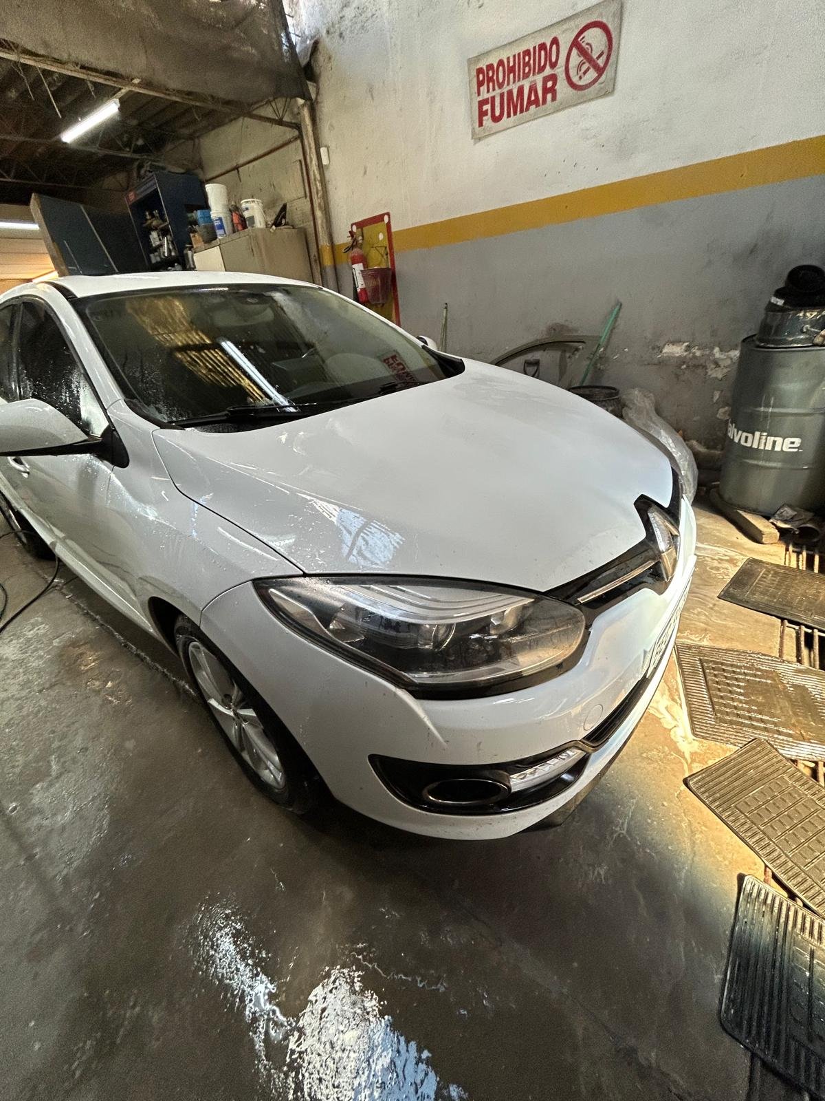 Renault blanco de frente, recién lavado, dentro del taller Quebecar